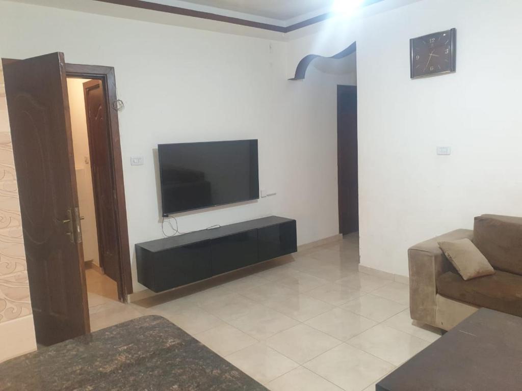 安曼的住宿－شقة مفروشة فرش فاخر ٣ غرف نوم في طبربور عمان，客厅设有壁挂式平面电视。