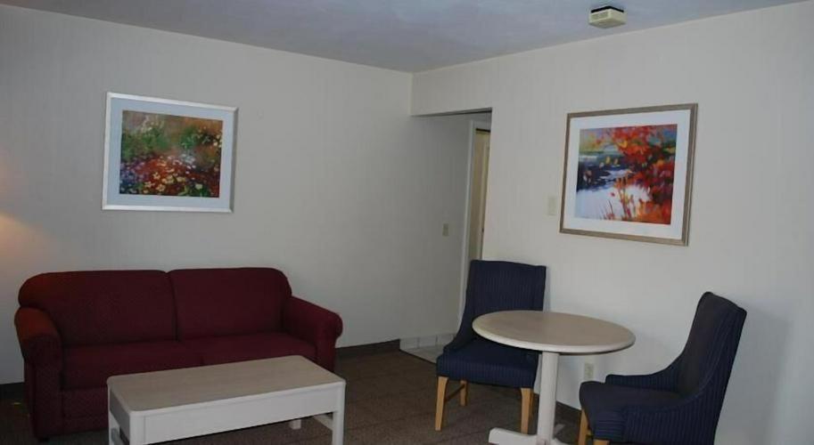a living room with a couch and a table and chairs at Clinton Inn & Suites in Port Clinton