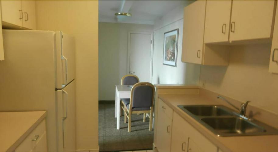 a kitchen with a table and chairs and a refrigerator at Clinton Inn & Suites in Port Clinton