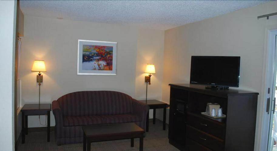 a hotel room with a chair and a television at Clinton Inn & Suites in Port Clinton