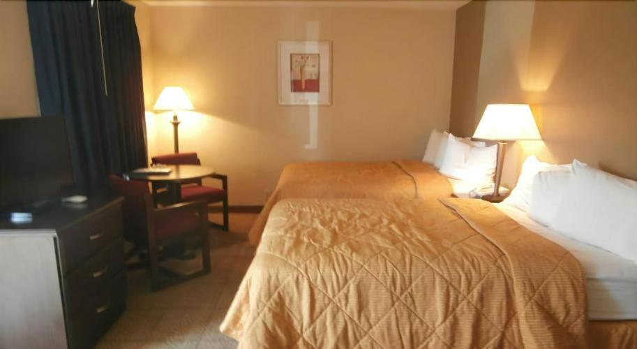 a hotel room with two beds and a television at Clinton Inn & Suites in Port Clinton