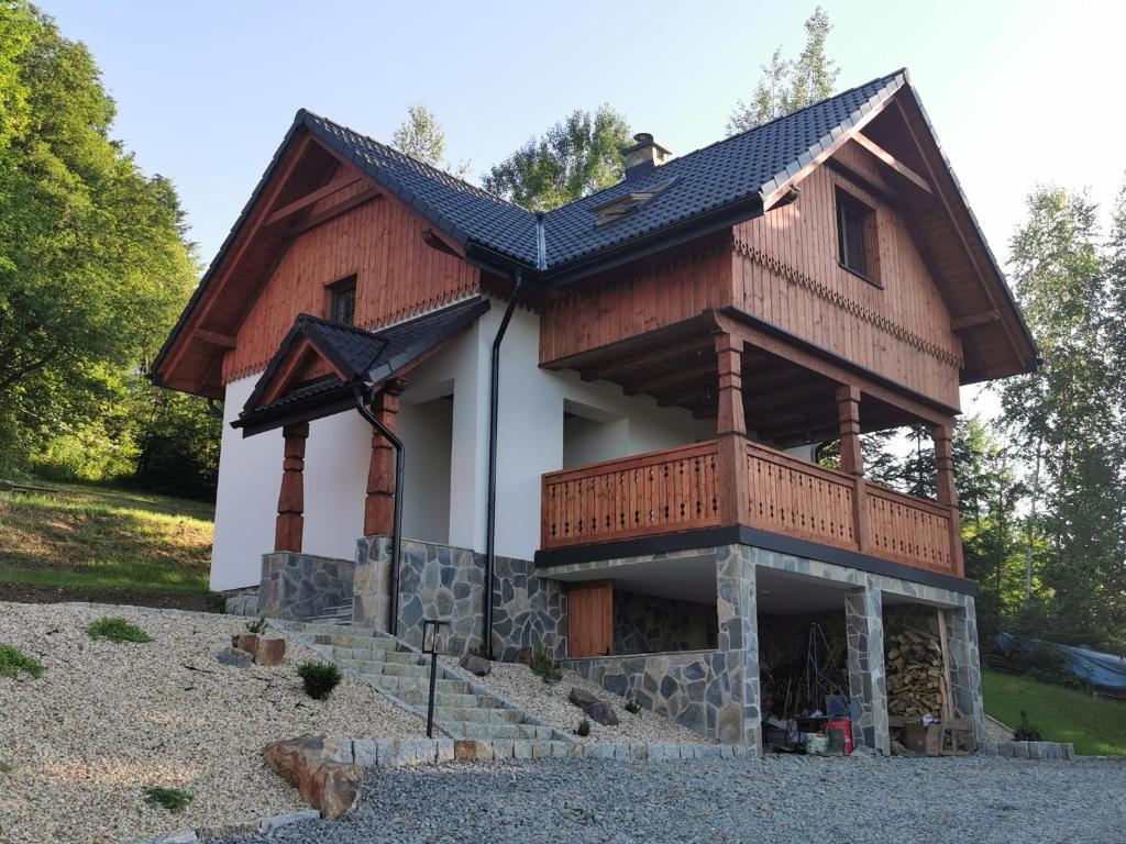 a house with a balcony on top of it at DOMEK POD CZEREMCHĄ in Zawóz