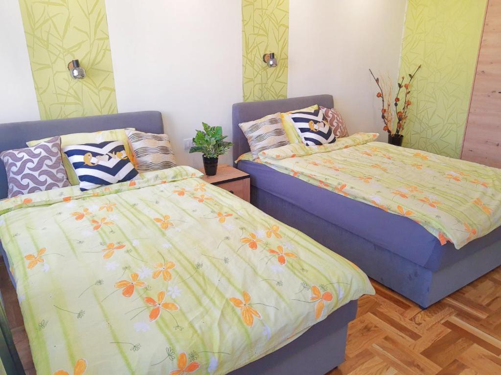 dwa łóżka siedzące obok siebie w sypialni w obiekcie Kalemegra w Belgradzie