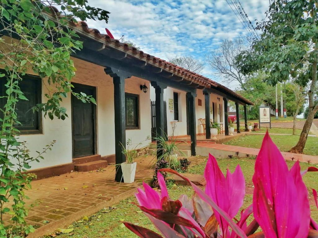 une maison avec des fleurs roses devant elle dans l'établissement Santa Maria Hotel, à Santa María
