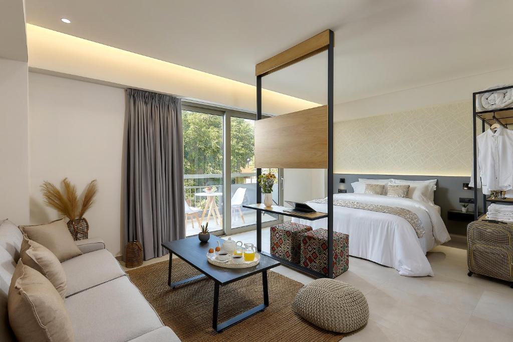 伊拉克利翁鎮的住宿－Stay 365 Heraklion Apart Hotel，一间卧室配有一张床、一张沙发和一张桌子
