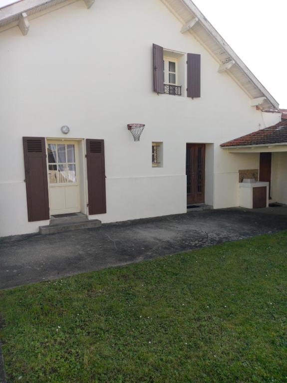 une maison blanche avec un panier de basket dans la cour dans l'établissement les hortensias, à Saujon