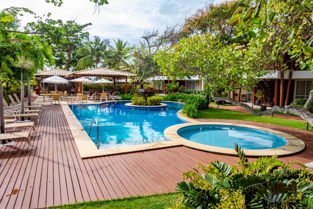 uma imagem de uma piscina num resort em Village Enseada Ville, Itacimirim, Bahia em Itacimirim