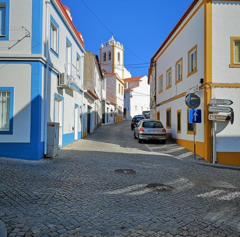 uma rua de calçada com edifícios e um carro estacionado em casa da vila em Mora