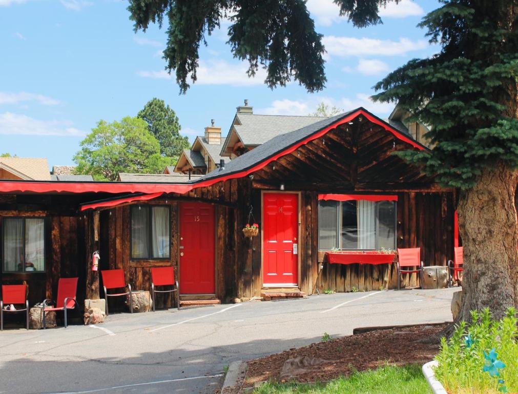 un edificio con puertas rojas y sillas en la calle en Foot of the Mountain Motel en Boulder