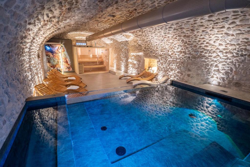 a swimming pool in a room with a stone wall at La Meridiana in Costermano