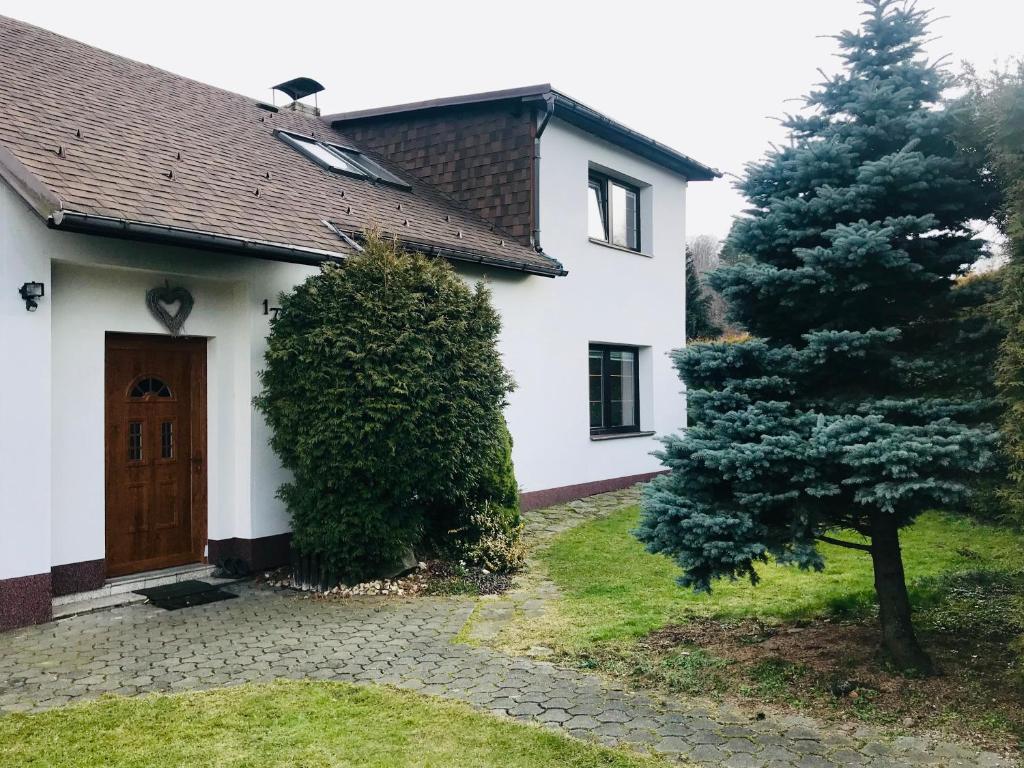 une maison blanche avec un arbre en face dans l'établissement Chalupa s vnitřním bazénem, à Frýdlant nad Ostravicí