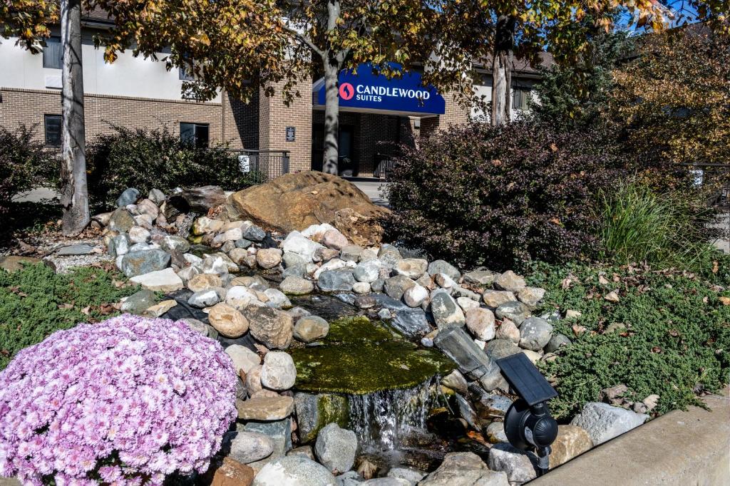 a rock garden with a waterfall and flowers at Candlewood Suites East Lansing by IHG in Lansing