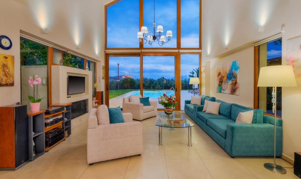 salon z niebieskimi kanapami i telewizorem w obiekcie Villa Elva Nafplio w Nauplionie