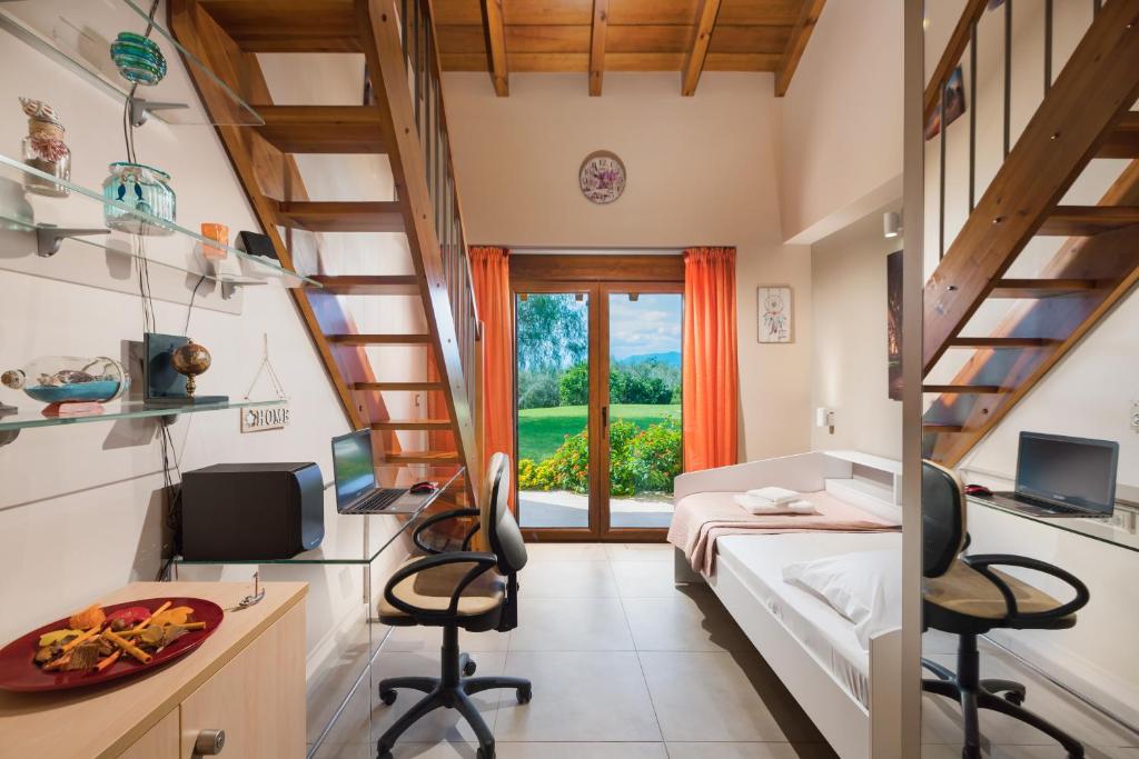 Pokój z łóżkiem, biurkiem i krzesłami w obiekcie Villa Elva Nafplio w Nauplionie