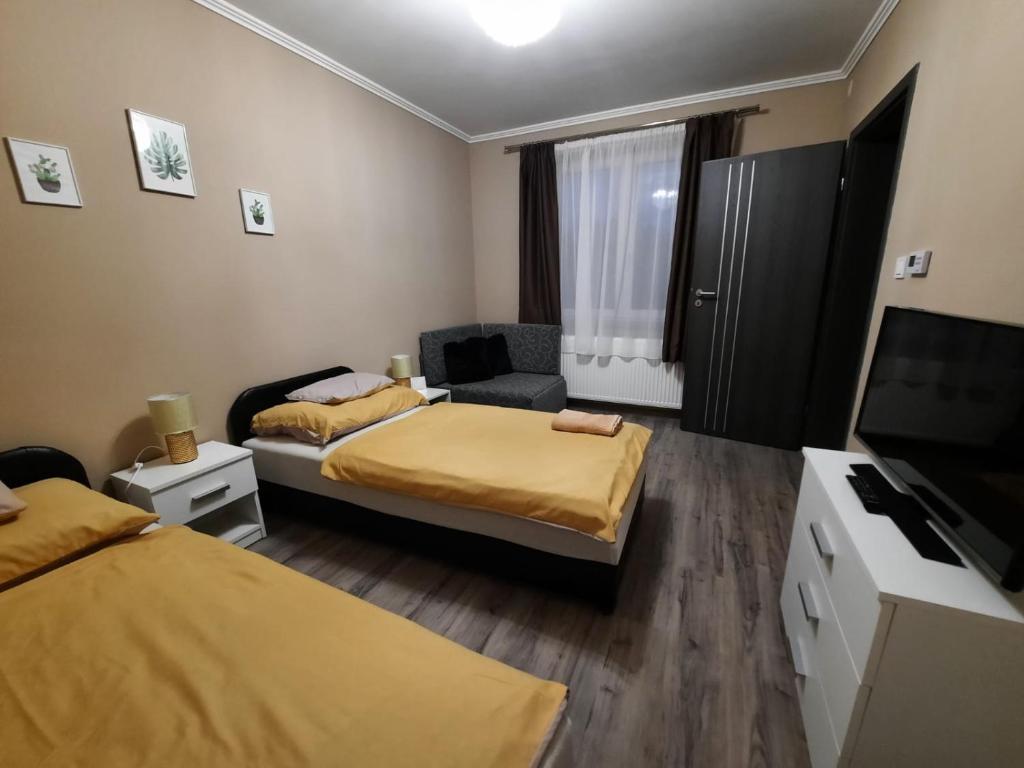 a small room with two beds and a television at Borostyán Panzió in Debrecen