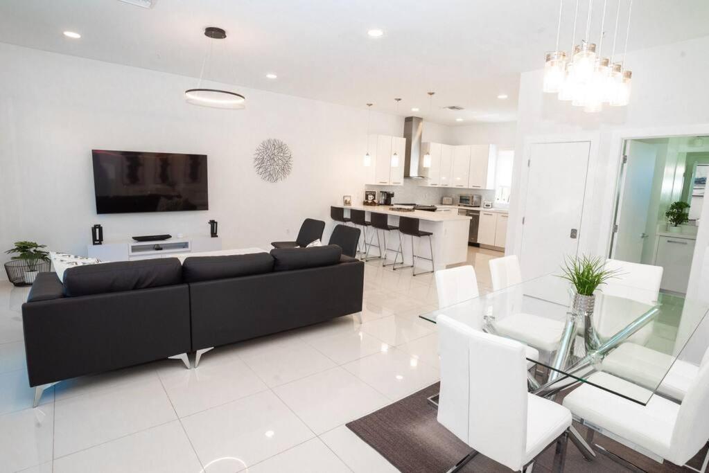 a living room with a black couch and a table at Across the Ocean few steps to beach contemporary three Bedroom townhouse in Pompano Beach