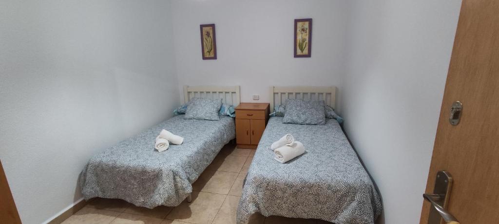 2 Einzelbetten in einem Zimmer mit 2 Handtüchern in der Unterkunft Casa Maria in Sant Carles de la Ràpita