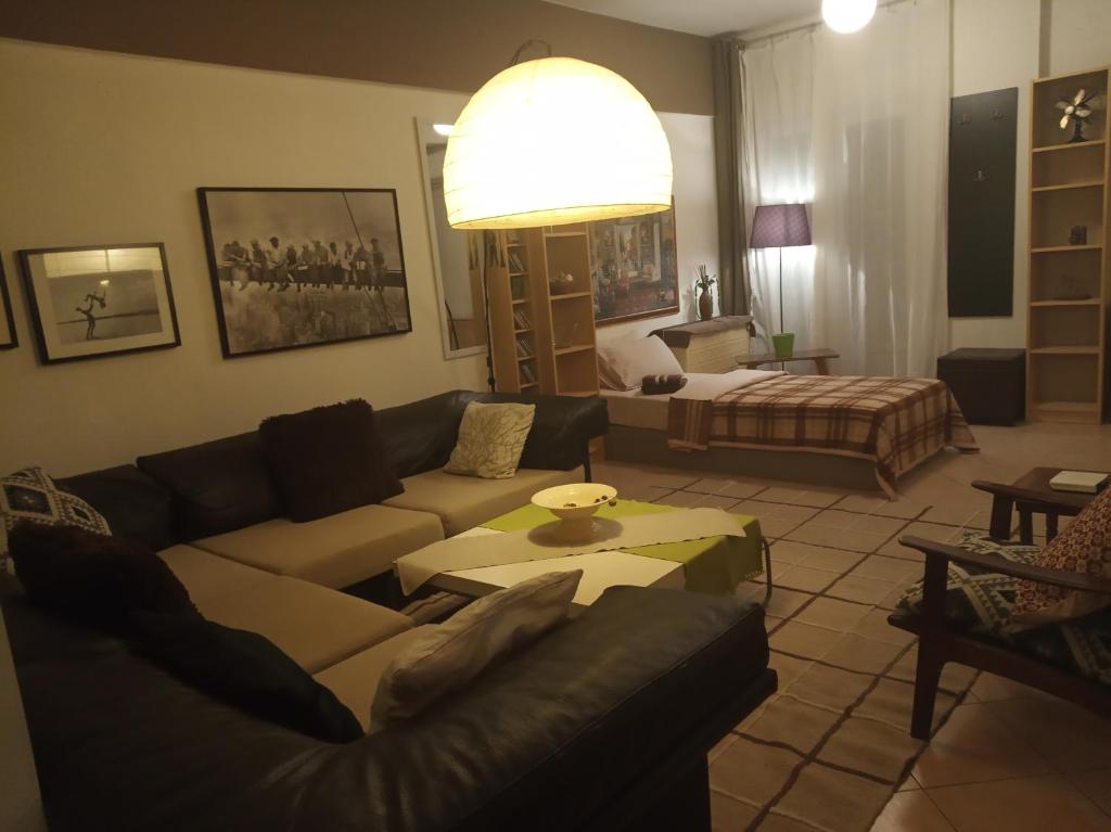 ein Wohnzimmer mit einem Sofa und einem Tisch in der Unterkunft Spacious Cosy Apt (up to 5 guests) in Thessaloniki
