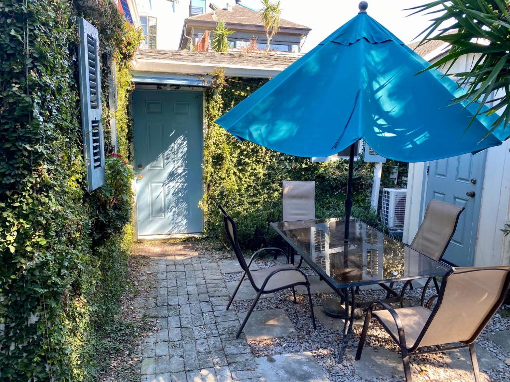 a patio with a table and an umbrella at Antonine Apartment Upper Garden District in New Orleans