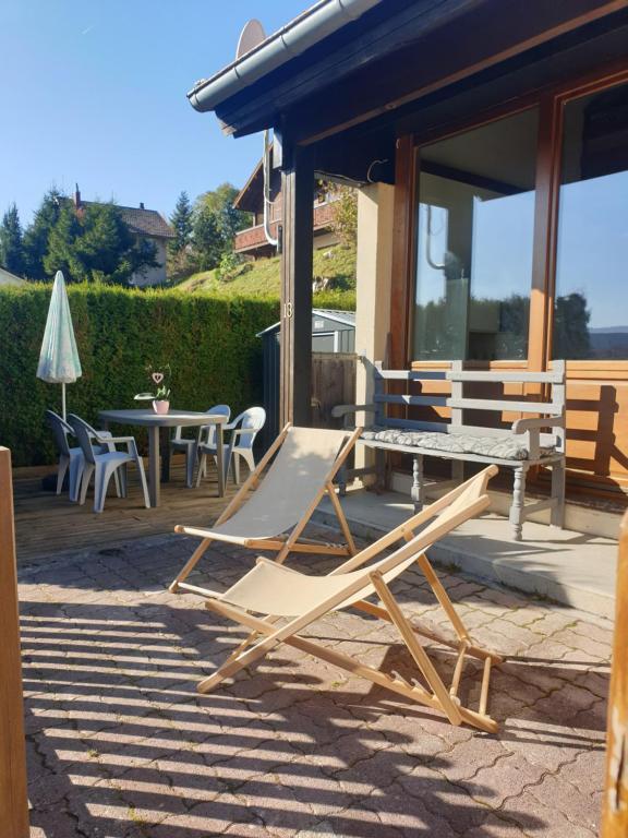 eine Gruppe Stühle und ein Tisch auf einer Terrasse in der Unterkunft Duplex de charme avec terrasse in Les Hôpitaux-Neufs