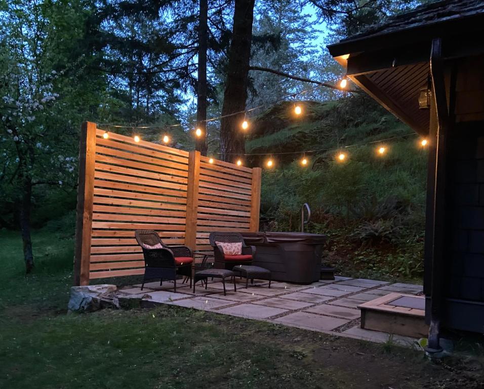 a patio with two chairs and a table and a tub at Amante Luxury Bed & Breakfast in Victoria