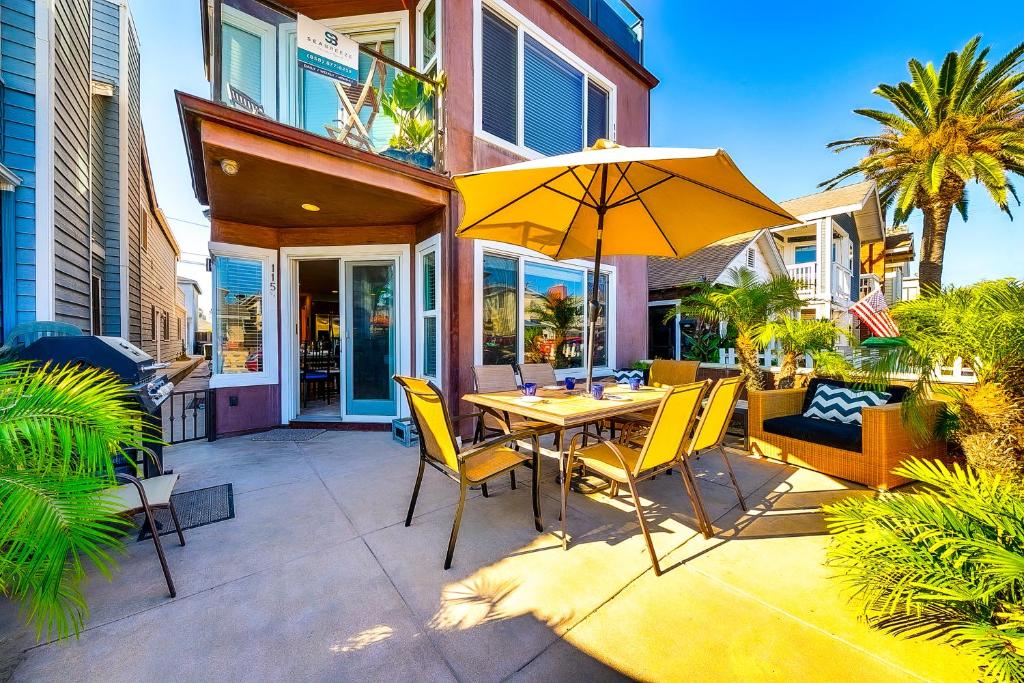 a patio with a table and chairs and an umbrella at Tropical Awesome in Newport Beach
