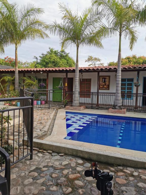 a house with a swimming pool and palm trees at Villa del Sol Hotel & Restaurante in Villavieja