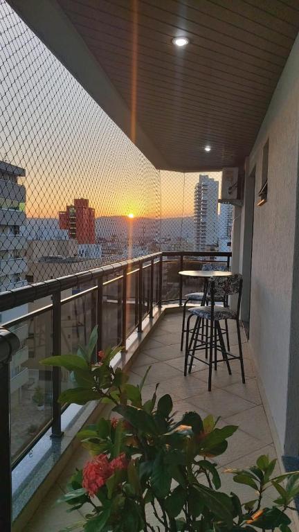 - Balcón con mesa y sillas en un edificio en Lindo Apartamento no Guarujá - Enseada, en Guarujá