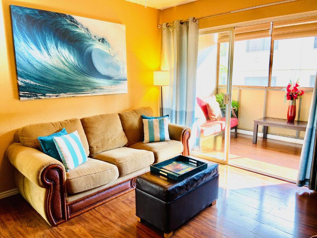a living room with a couch and a large wave on the wall at Palani Condo in Kailua-Kona