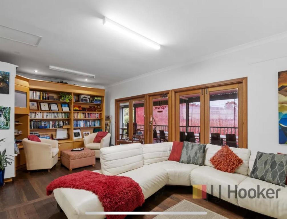a living room with a white couch and bookshelves at Pemberton Lodge in Pemberton