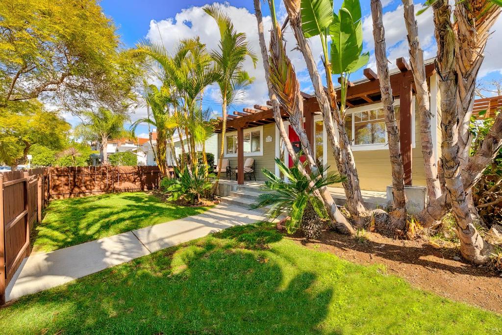 a house with palm trees and a fence at Charming Hillcrest Craftsman in San Diego