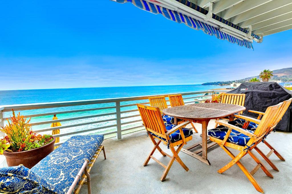 a table and chairs on a balcony with the ocean at Laguna Beach Oceanfront in Laguna Beach