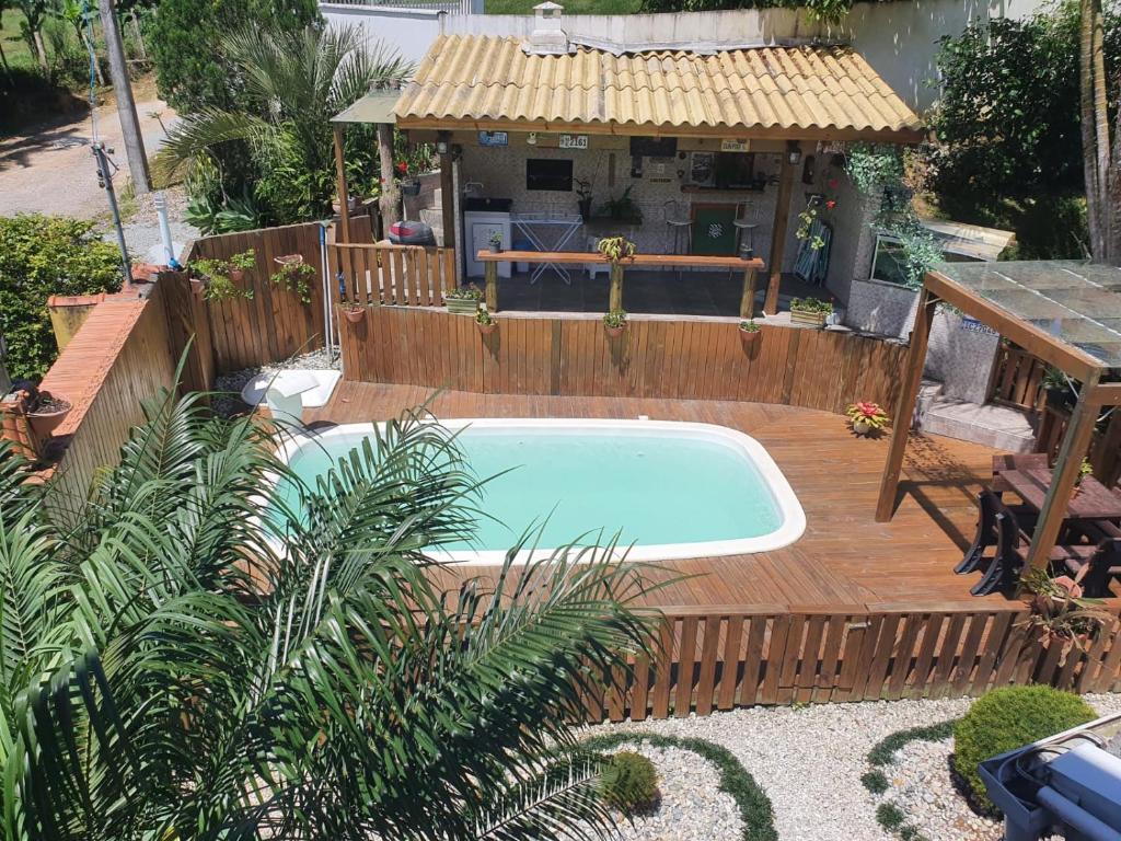 a swimming pool on a wooden deck next to a house at Pousada Korb in Santo Amaro da Imperatriz