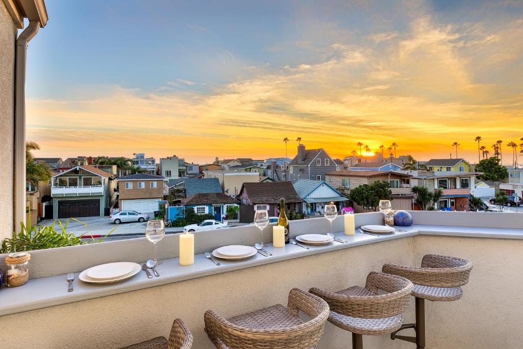 a table on a balcony with a view of a city at Newport Pier Townhome in Newport Beach
