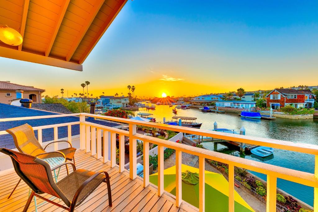 a balcony with chairs and a view of a river at Newport Bay Front Vacation Home in Newport Beach