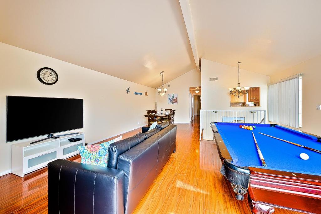 ein Wohnzimmer mit einem Billardtisch und einem TV in der Unterkunft Beach Living 1 in Newport Beach