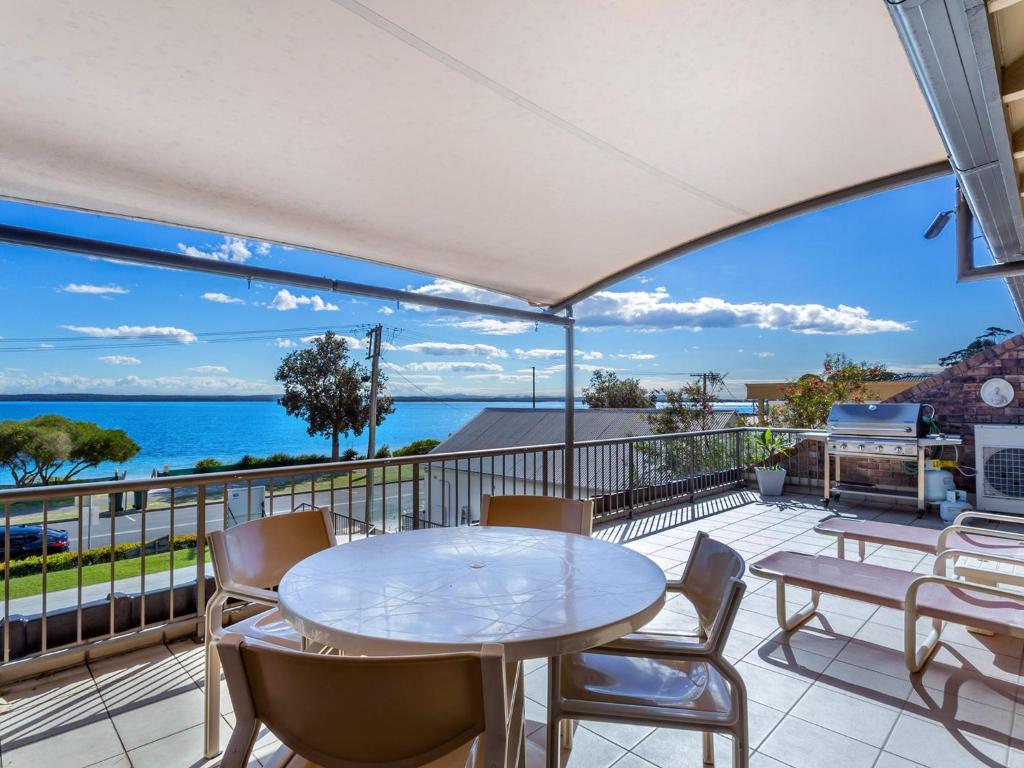 a patio with a table and chairs and the ocean at A Yachtsmans Rest, Unit 4/37 Victoria Parade in Nelson Bay