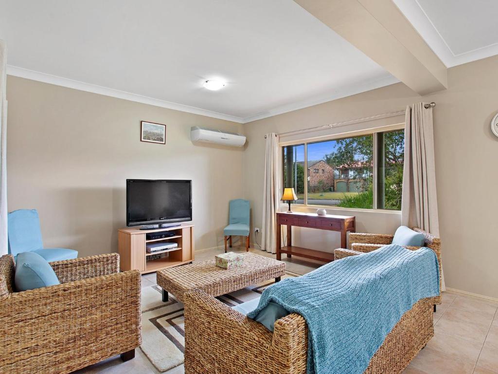 a living room with wicker furniture and a flat screen tv at Ajax Avenue 6 in Nelson Bay
