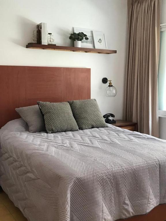 a bedroom with a large bed with a wooden headboard at Mesón San Felipe in Guadalajara