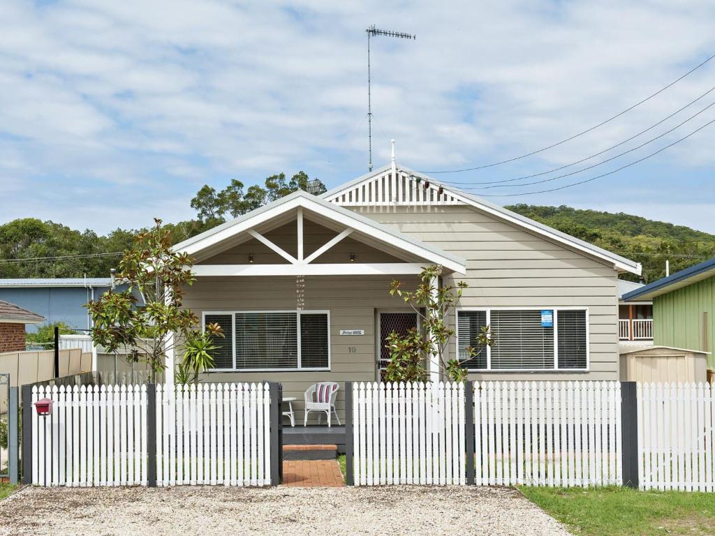 una recinzione bianca di fronte a una casa di Harry's House a Shoal Bay