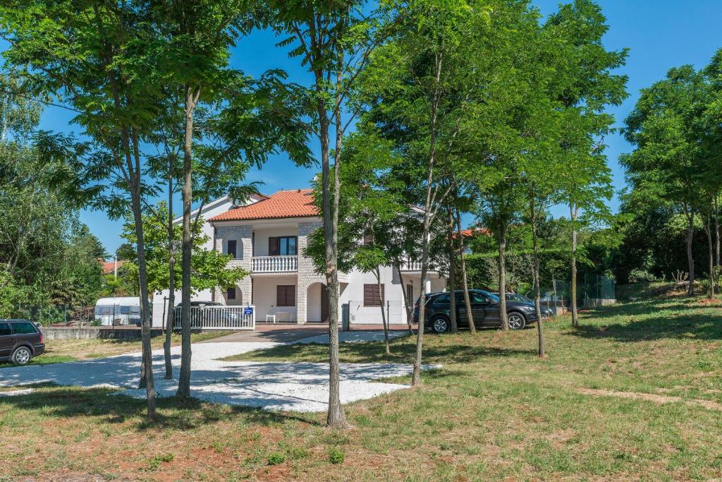 a house with a lot of trees in front of it at Apartments Vienna in Zambratija