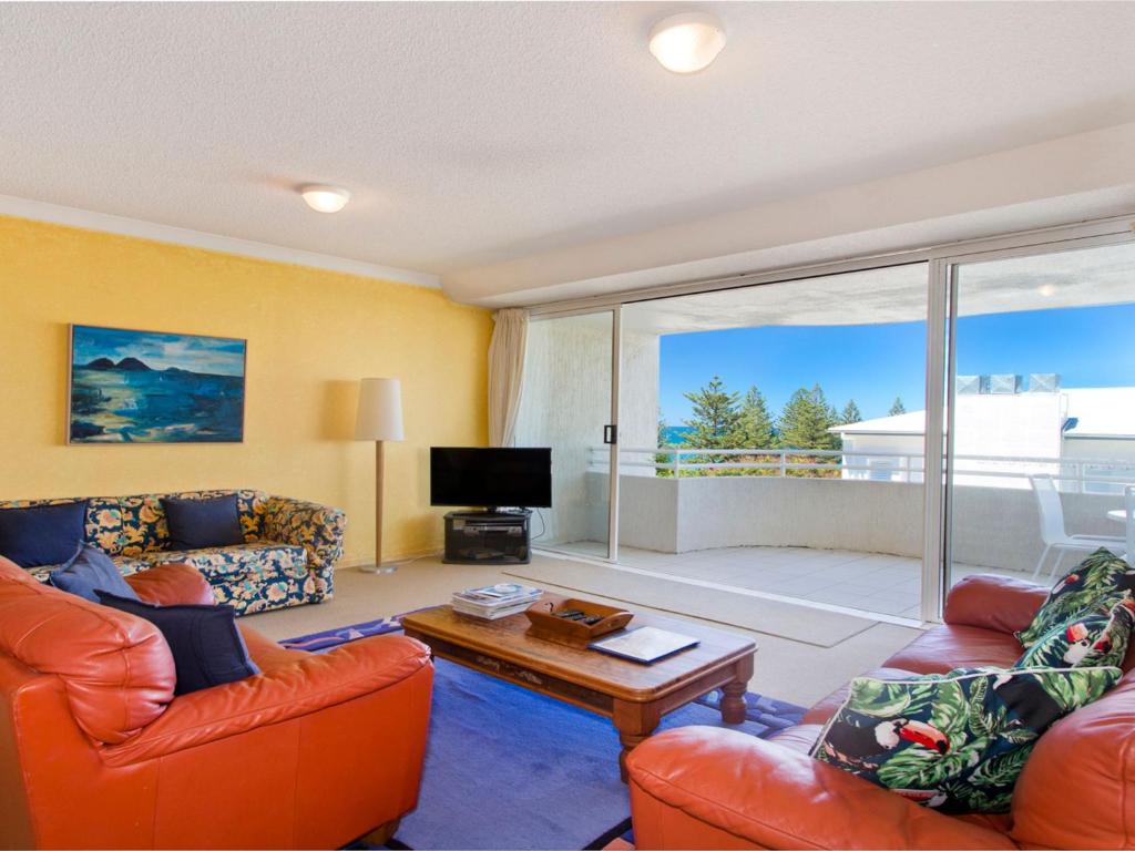 a living room with orange furniture and a large window at Cote DAzur 6 Douglas Street 6 in Sunshine Beach