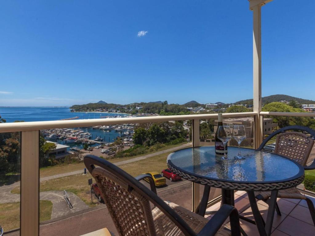 un tavolo e sedie su un balcone con vista sull'oceano di Laman Lodge Unit 5 15 Laman Street a Nelson Bay