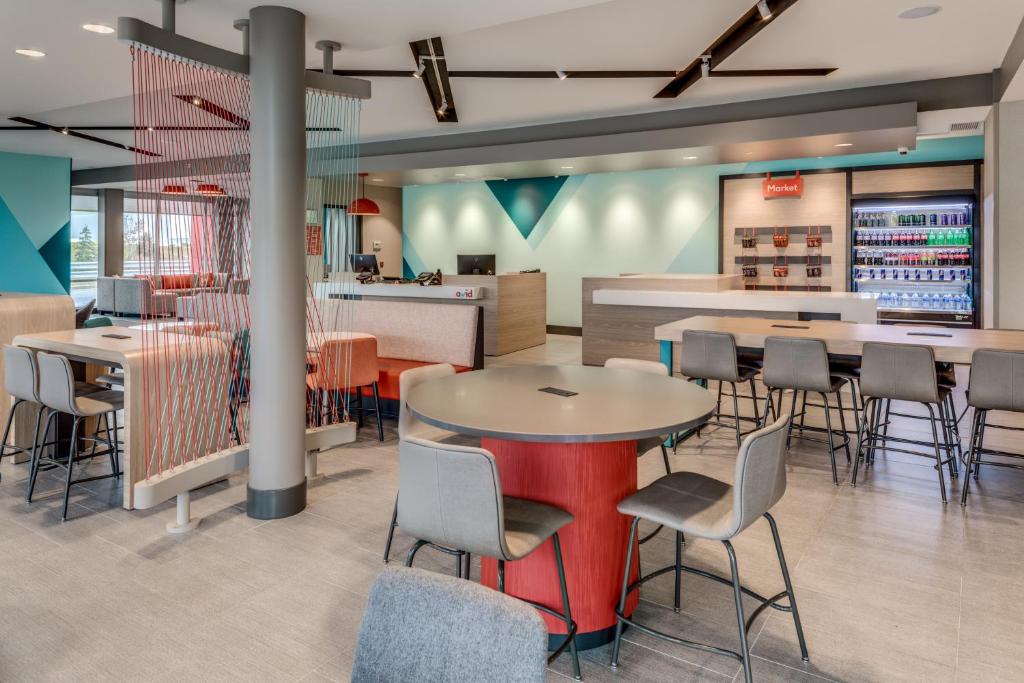 a restaurant with tables and chairs and a bar at avid hotels - Zeeland by IHG in Holland