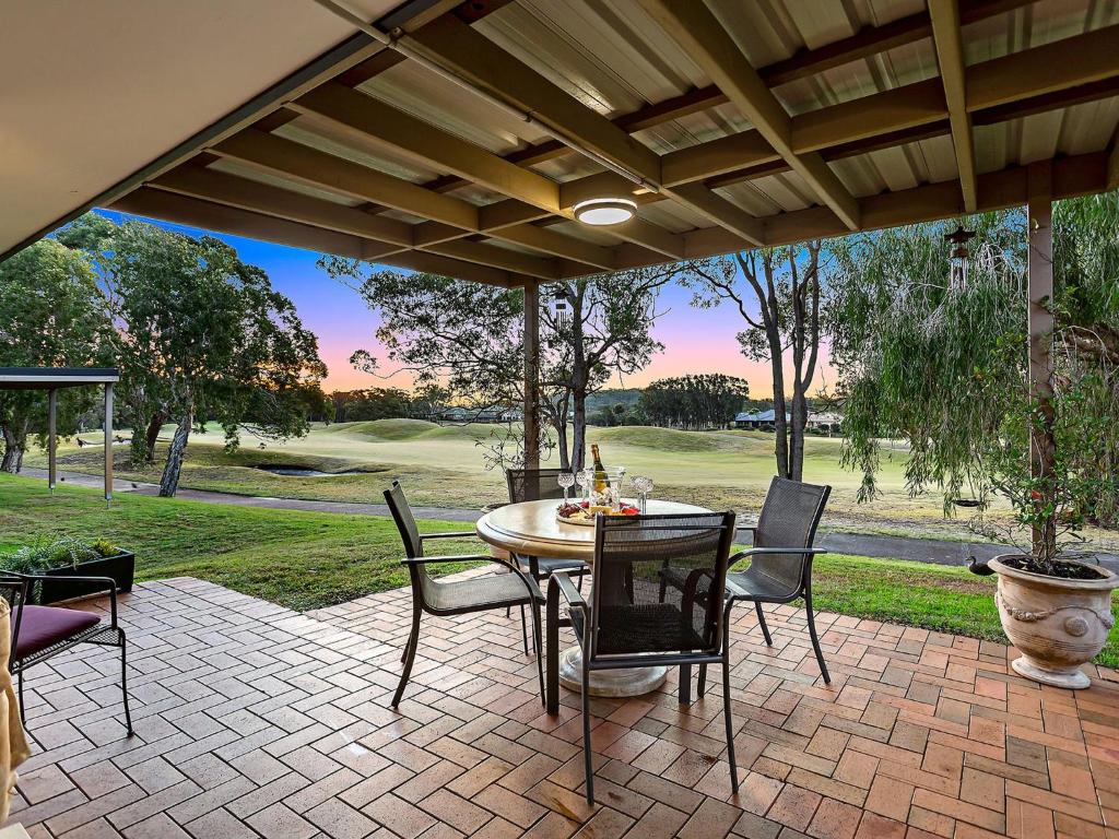 un patio con mesa y sillas en Horizons Escape Villa 136, en Salamander Bay