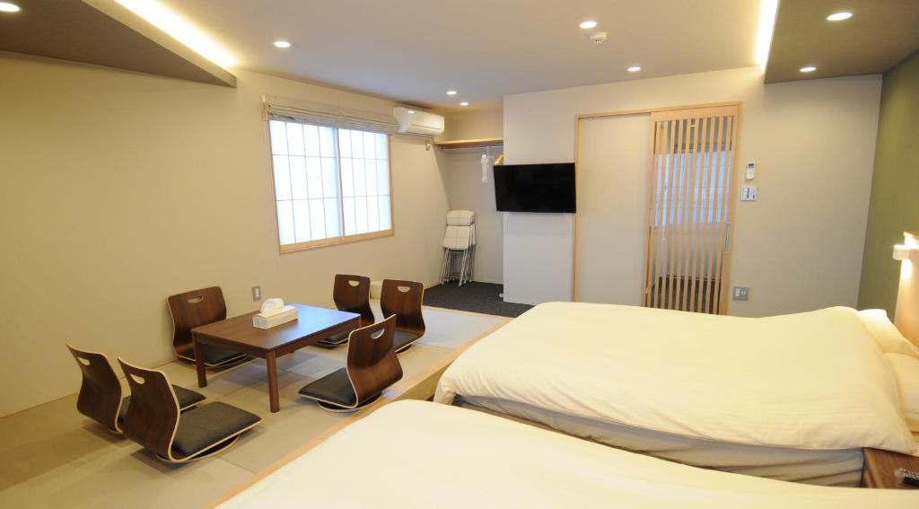 um quarto de hotel com duas camas e uma mesa e cadeiras em HIZ HOTEL Kyoto-Nijo Castle em Quioto