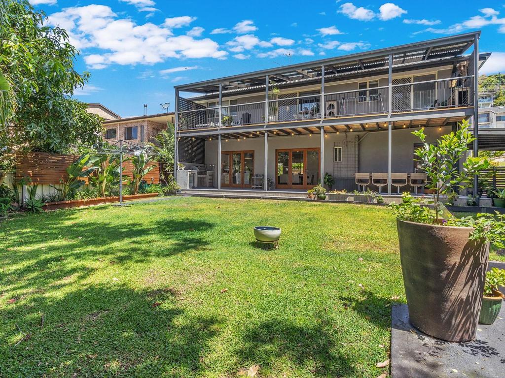 a large yard with a building with a balcony at Private coastal getaway Corlette in Corlette