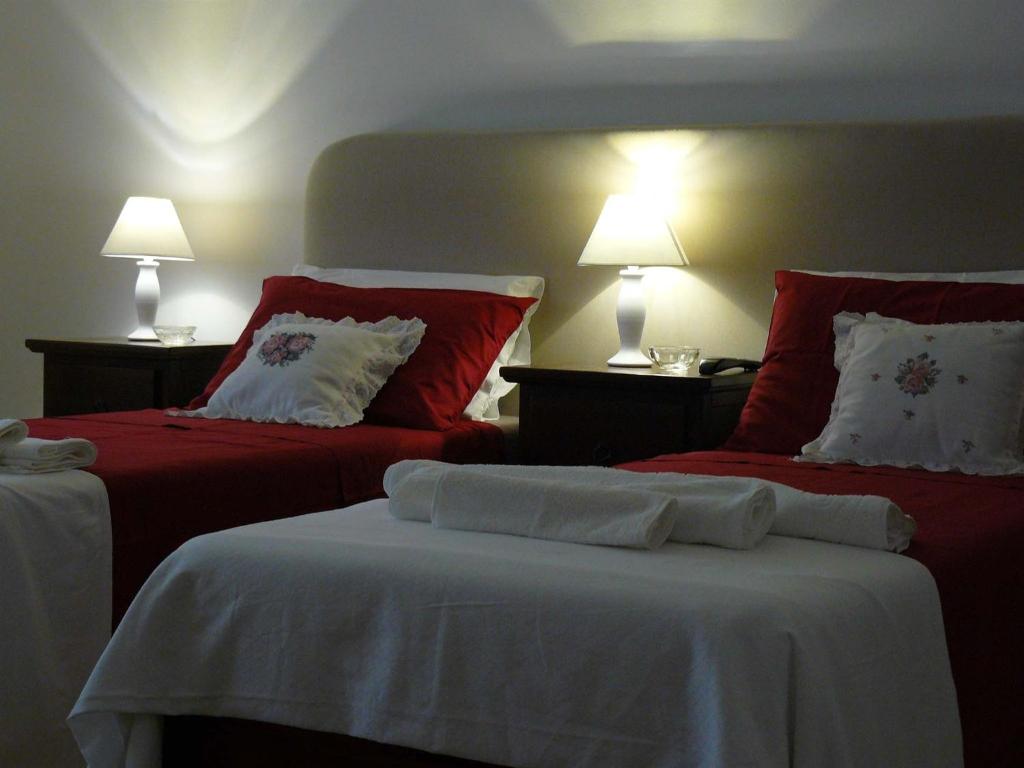 a bedroom with two beds with red and white pillows at Casa Dani in Cerfignano