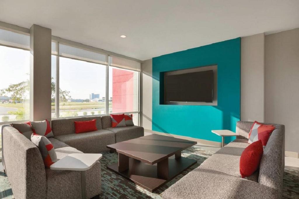 a living room with a couch and a tv at avid hotels - Zeeland by IHG in Holland