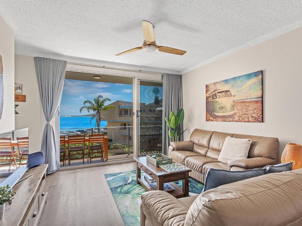 a living room with a couch and a view of the ocean at Bella Vista Unit 10 19 Shoal Bay Road in Shoal Bay